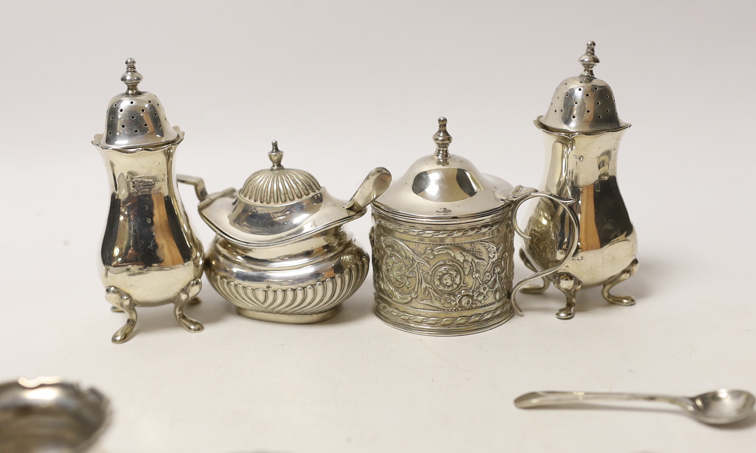 Two pairs of small silver salts, a pair of silver pepperettes, and two silver mustard pots including late Victorian, together with five small spoons (one silver).
